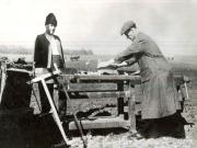 Fotografie: Muncitori reparând uneltele ţăranilor direct pe tarlale, ajutându-i în campania agricolă de însămânţări.(1946)