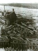 Fotografie: La S.M.T. Băileşti, regiunea Craiova, o femeie pe un tractor trăgând discuitoare.(1952)