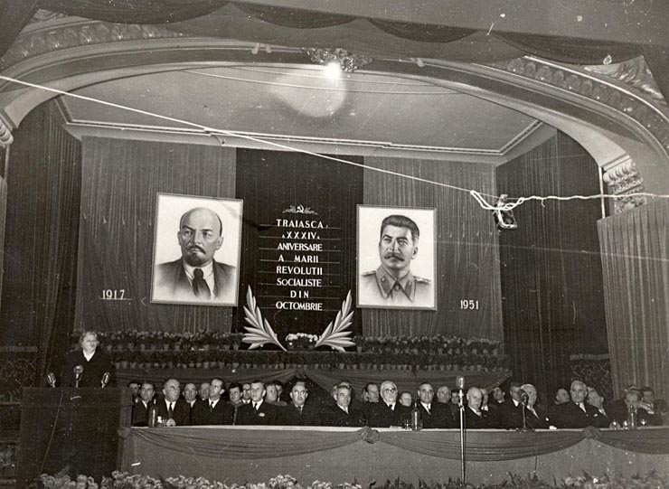 Gheorghe Gheorghiu –Dej, Lothar Rădăceanu, Florin Dănălache, Al. Moghioroş, Chişinevselu Iosif, C.I. Parhon, Kavtaradze S.I,  Vasile Luca, Ana Pauker (vorbind), Petru Groza, Nichitin în prezidiul şedinţei solemne consacrată celei de-a 34-a aniversări a Marii Revoluţii Socialiste din Octombrie (Sala Ateneului R.P.R.). (6.11.1951).