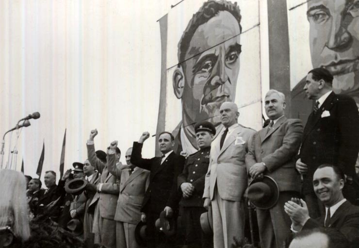 Gheorghe Gheorghiu –Dej, Petru Groza, Gh. Tătărăscu, Kavtaradze, Susaikov, Th. Georgescu, Zaroni, G-ral Vasiliu Răşcanu, P. Constantinescu-Iaşi în tribuna oficială, primind demonstraţia oamenilor muncii cu prilejul zilei de 1 Mai 1946 (Piaţa Victoriei). (01.05.1946).