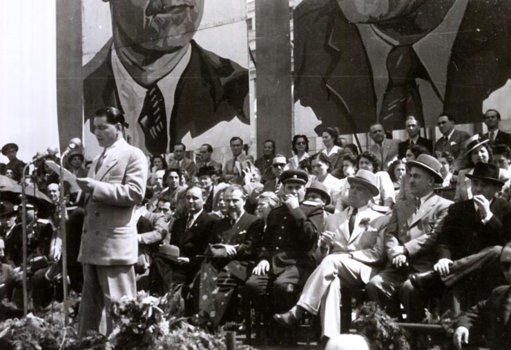 Tribuna oficială cu prilejul mitingului oamenilor muncii din Capitală, consacrată sărbătoririi zilei de 1 Mai. Sunt prezenţi: Gheorghe Gheorghiu –Dej, Petru Groza, Gh. Tătărăscu, Kavtaradze, Sasaikov, Şt. Voitec, Chivu Stoica, Ion Pas, Ana Pauker, Al. Moghioroş. (01.05.1946).