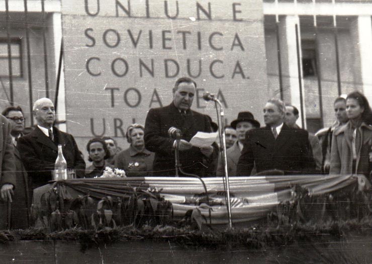 Gh. Gh.-Dej rostindu-şi cuvântarea la mitingul din Piaţa Victoriei, organizat cu prilejul sărbătoririi zilei internaţionale a femeii. În tribună se mai află: C. I. Parhon, Alexandru Moghioroş, Miron Constantinescu, Olimpia Tenescu, Ana Pauker, Vasile Luca, Teohari Georgescu. (8 martie 1950)