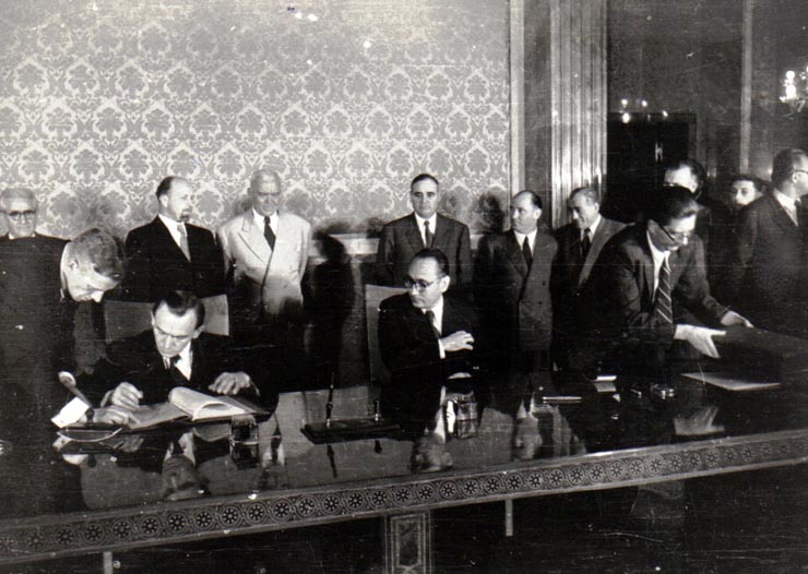 Gh. Gh.-Dej, Petru Groza, Walter Ulbricht, Grigore Preoteasa (semnând), Iosif Chişinevschi, Teohari Georgescu, Chivu Stoica, Miron Constantinescu la solemnitatea de la Consiliul de Miniştri, cu prilejul semnării declaraţiei comune şi a unor acorduri între R.P.R. şi R.D.G.(22 septembrie 1950)