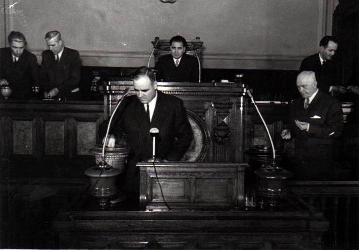 Gh. Gheorghiu-Dej votând proiectul de lege pentru aprobarea Bugetului de Stat al R.P.R. pe anul 1952.  Sunt prezenţi: Gh. Apostol, P. Groza, ş.a. (27.03.1952).