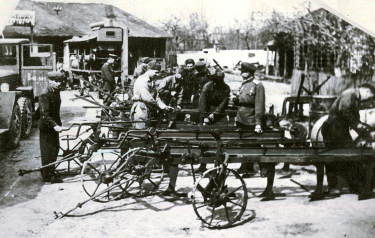 Fotografie: ostaşi din Armata Roşie ajutând la repararea uneltelor agricole la ţară, în 1945-1946.(1945-1946)