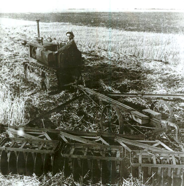 Fotografie: La S.M.T. Băileşti, regiunea Craiova, o femeie pe un tractor trăgând discuitoare.(1952)