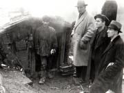 Gheorghe Gheorghiu-Dej în faţa unei case de miner din Valea Jiului. Se mai află de faţă Alexandru Moghioroş şi alte persoane (1944 noiembrie 24).