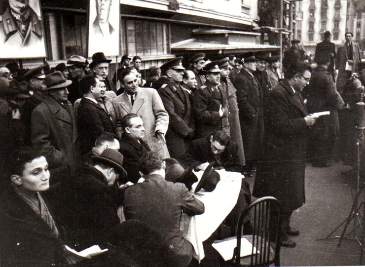 Manifestaţie F.N.D. cu prilejul actului festiv de reunire a Nordului Transilvaniei cu România democratică. Aspecte din Piaţa Palatului, în tribună Gheorghe Gheorghiu Dej, Ana Pauker, Vasile Luca, ş.a.(L.Pătrăşcanu, general Dămăceanu, Teohari Georgescu, g-ral Vasiliu Răşcanu, Petru Groza, preot C. Burducea).(14 martie 1945)